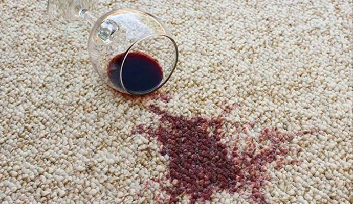 A glass of red wine spilled onto a rug