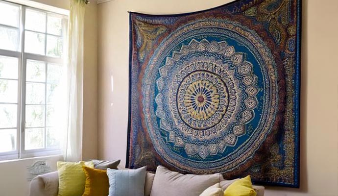 A large patterned rug hanging on a living room wall