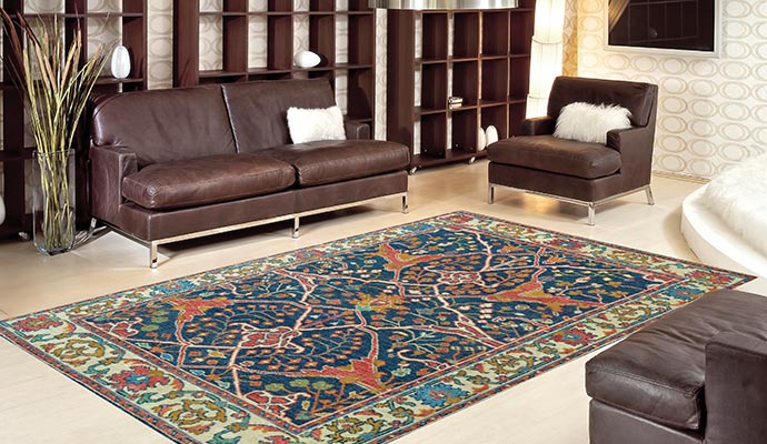 A large blue patterned area rug centered in a modern living room with leather furniture and wooden shelving