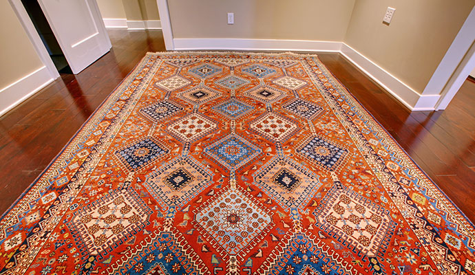 Colorful rug placed on wooden floor