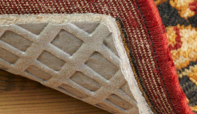Underneath view of an area rug with a cushioned non-slip rug pad attached
