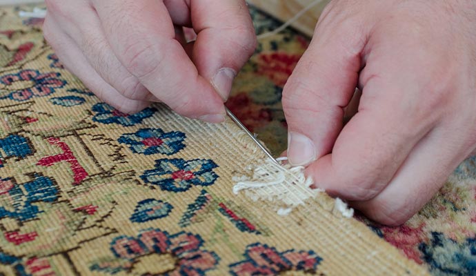 Person repairing rug