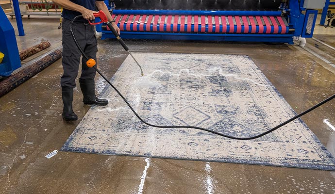 Pressure washing industrial area rug