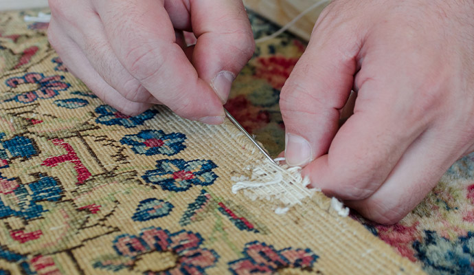Expert reweaving missing section of rug