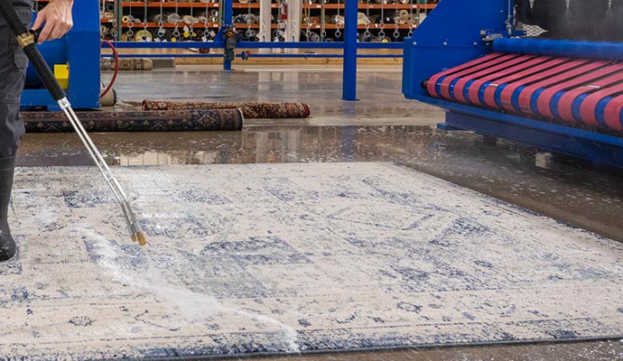 worker cleaning rug professionally