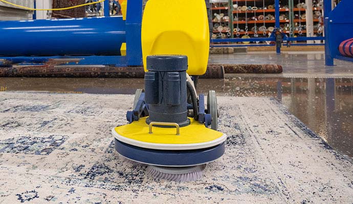 Rotary machine scrubber performing deep cleaning on an area rug