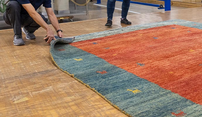 Worker inspecting and following up on rug