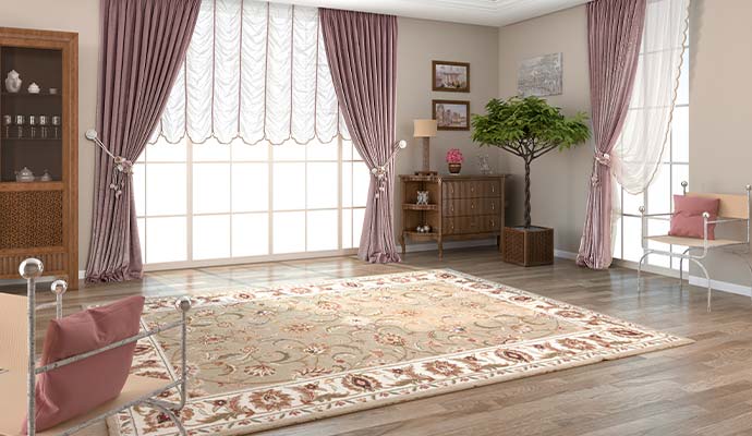 Natural sunlight shining through large windows onto an area rug in a living room