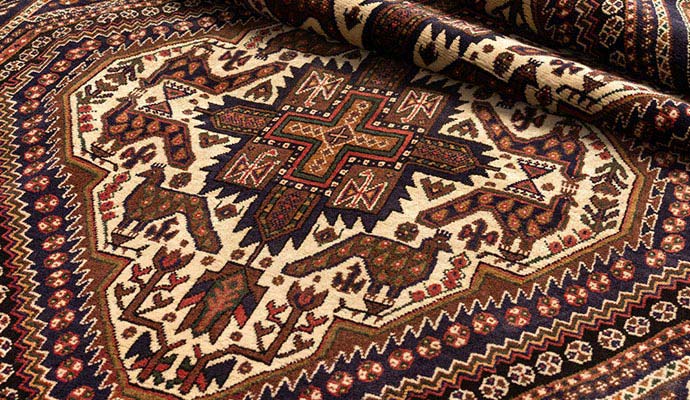 Intricate geometric and bird motifs on a traditional dark oriental rug
