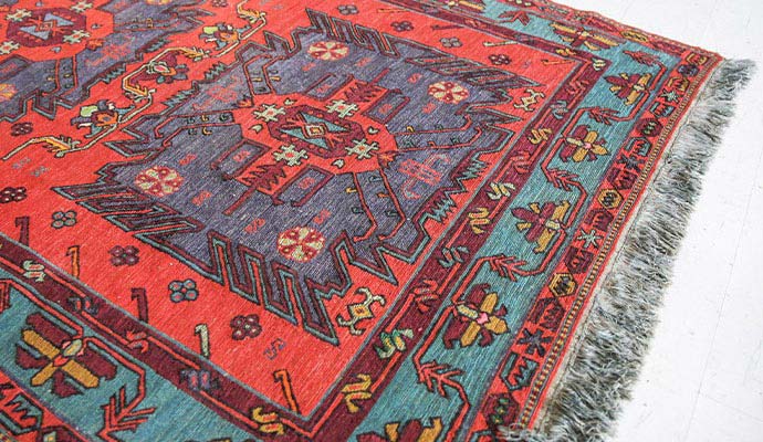 Traditional Turkish area rug featuring geometric patterns in red and teal