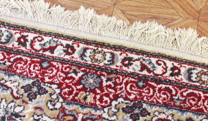 worker cleaning rug with equipment