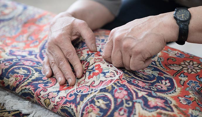 worker repairing rug