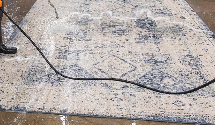 worker cleaning rug